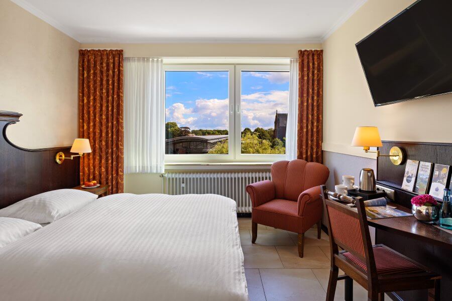 Doppelzimmer mit Blick ins Grüne und Vorhängen